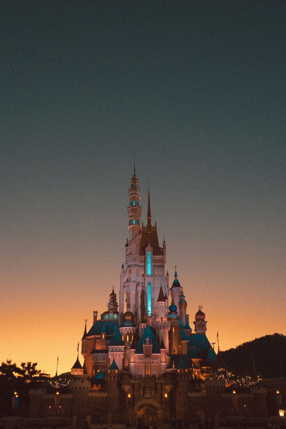 Un castillo iluminado por la noche con un fondo de cielo