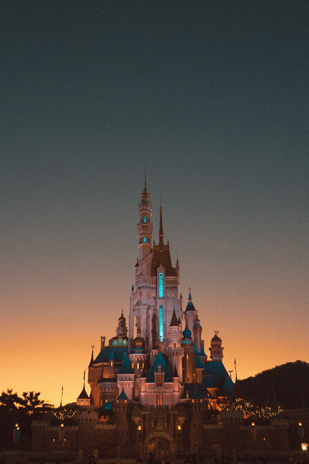 a castle lit up at night with a sky background