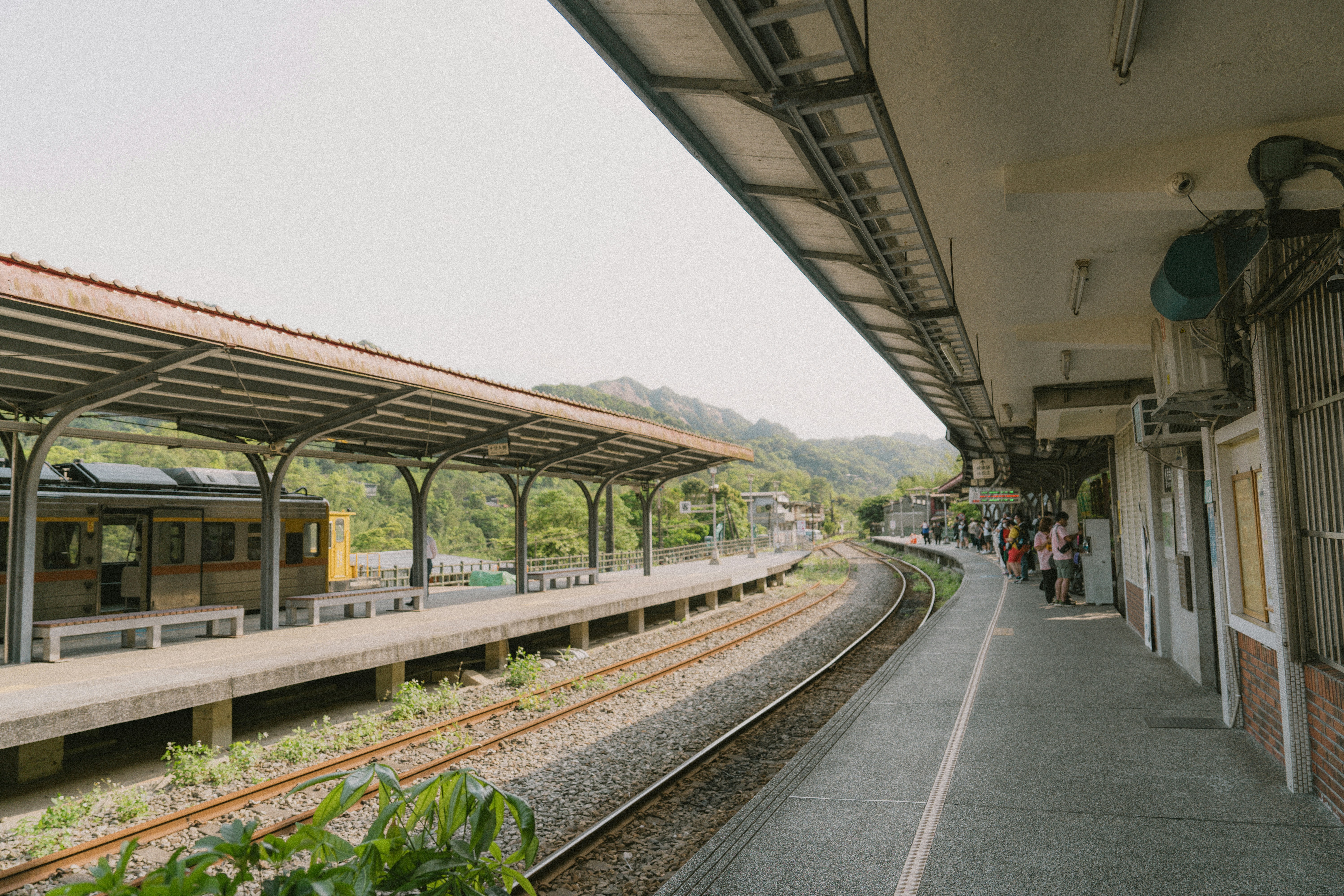 a train station with people waiting for the train