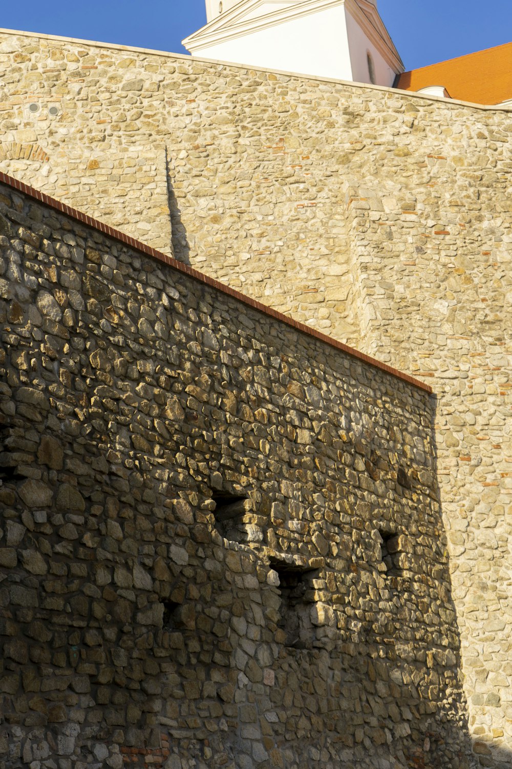 a stone wall with a clock tower in the background