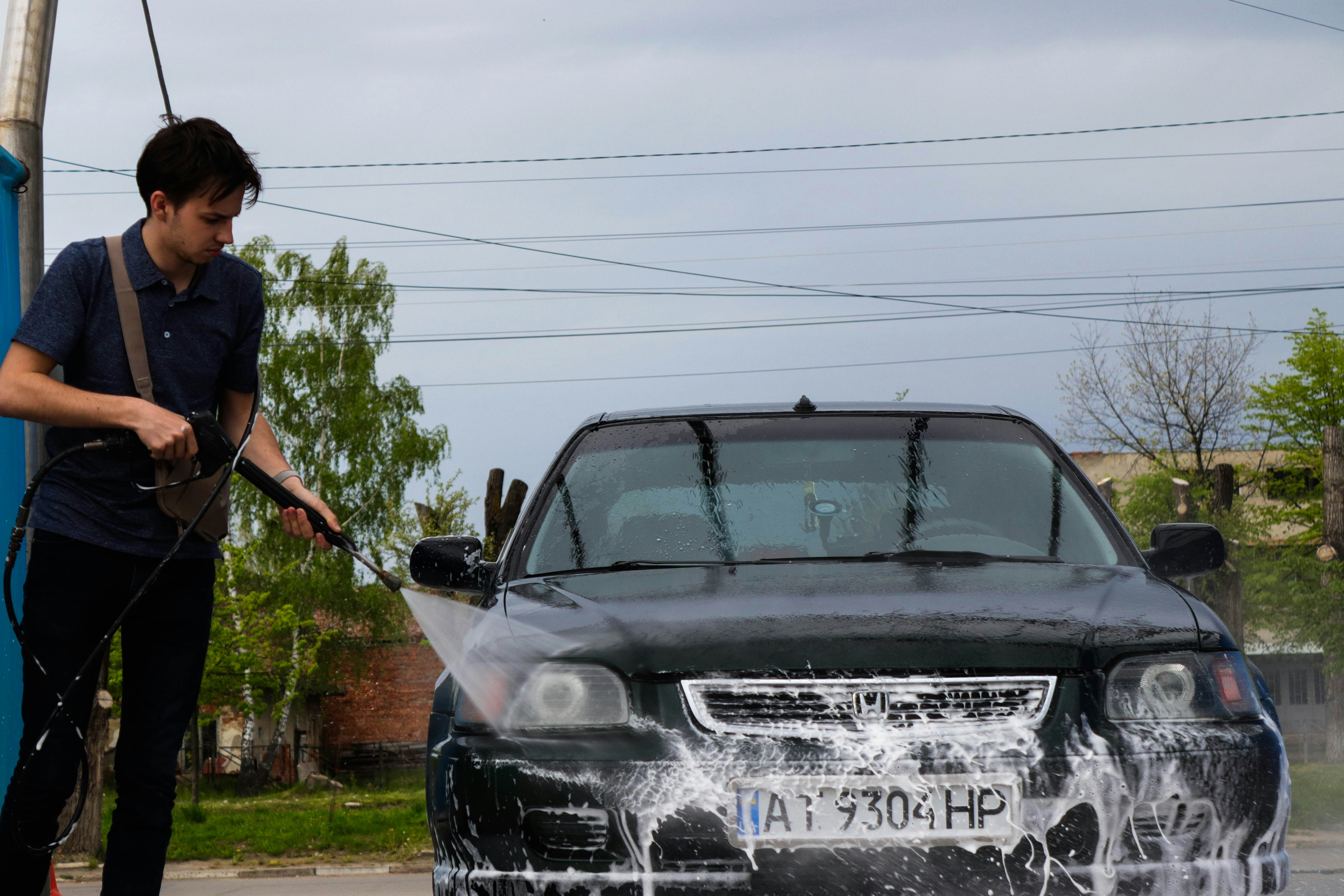 Profesionalno pranje automobila, mlaz vode, tamna pozadina, sijaj karoserije