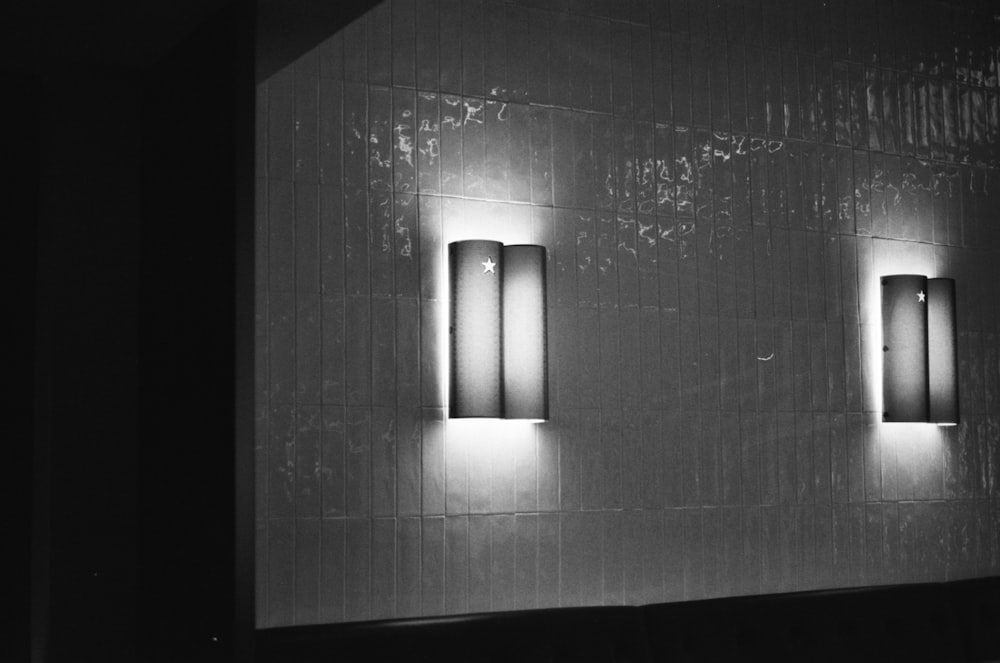 a black and white photo of three lights on a wall