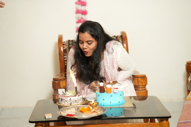 A joyful moment of the birthday woman blowing out candles on a beautifully decorated cake.