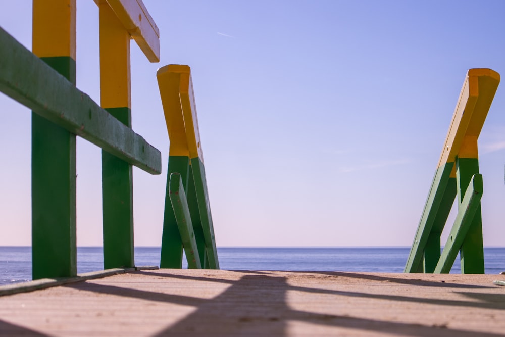 a bench sitting on top of a sandy beach next to the ocean