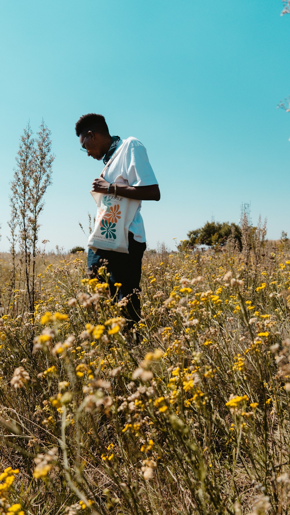 a man standing in a field of yellow flowers