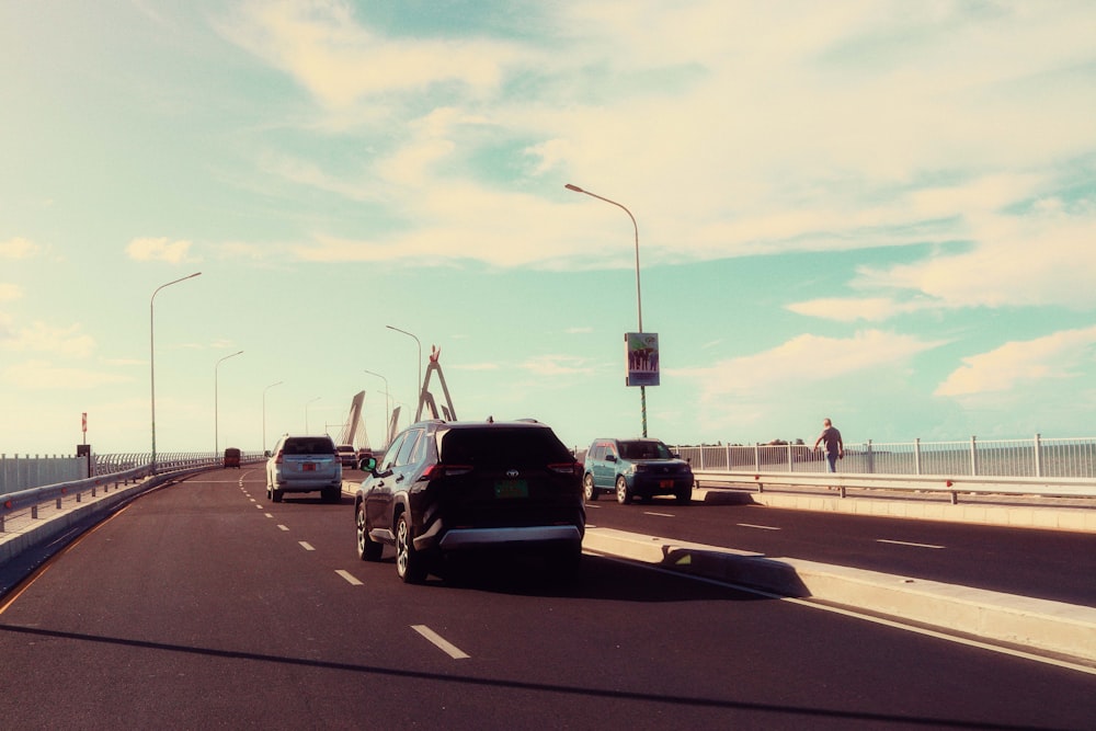 cars driving on a highway with a bridge in the background