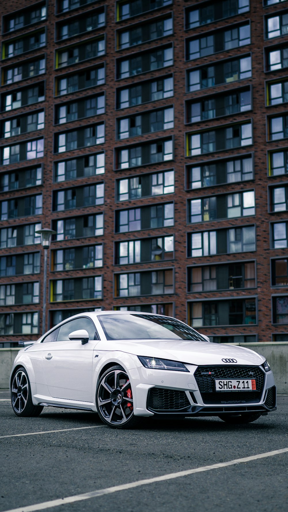 a white car parked in front of a tall building