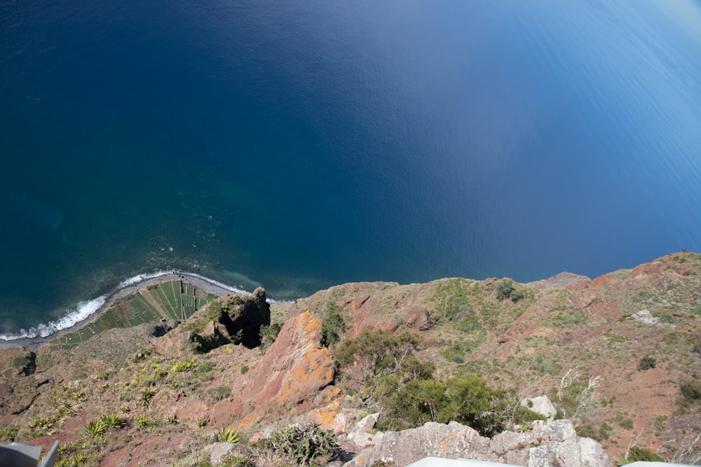 a man standing on top of a mountain next to a body of water