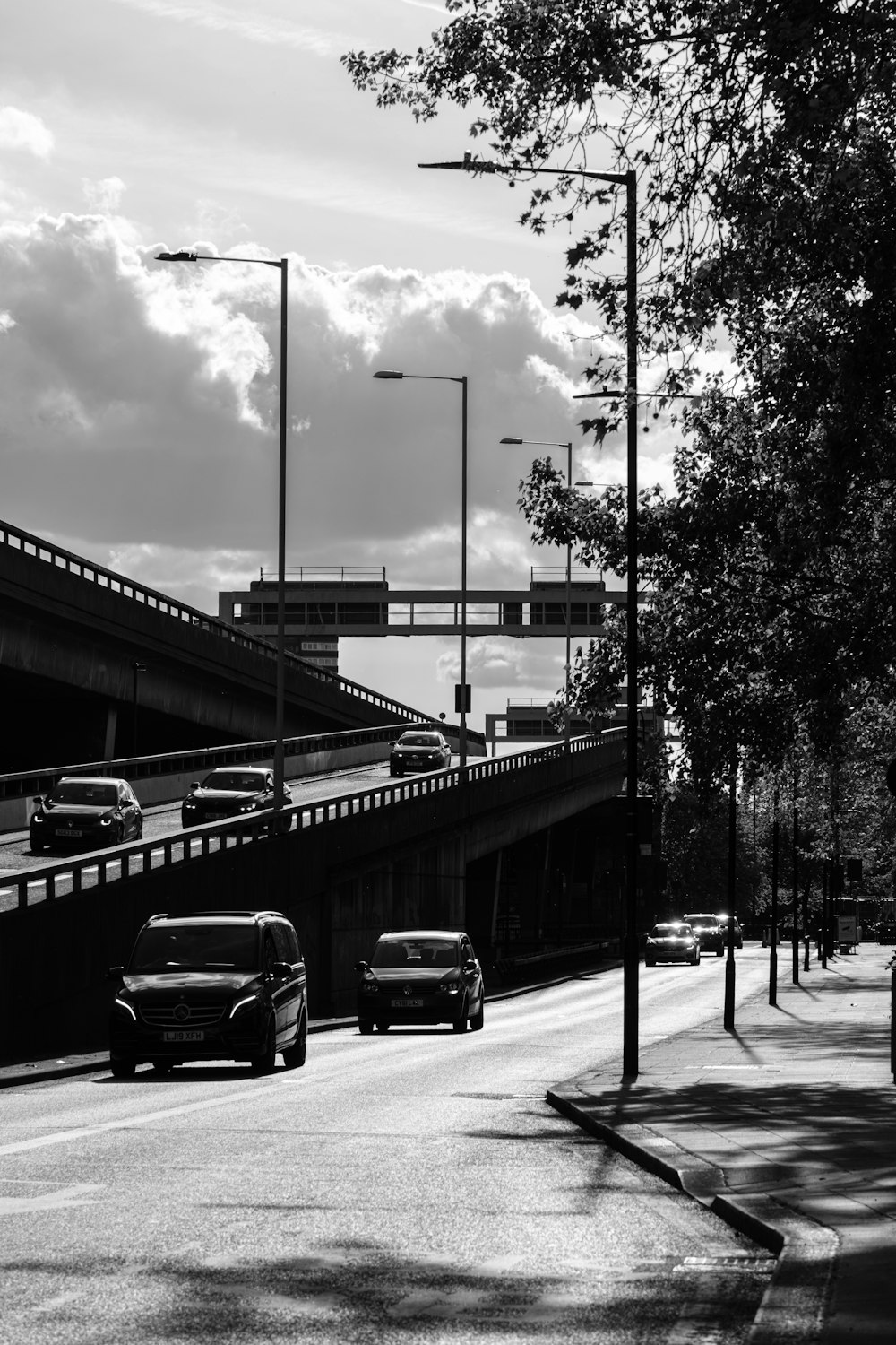 a black and white photo of cars driving on a highway