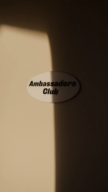 a white sign that reads ambassadors club on it