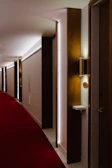 Stylish hotel corridor showcasing a blend of black charcoal and warm off-white walls.
