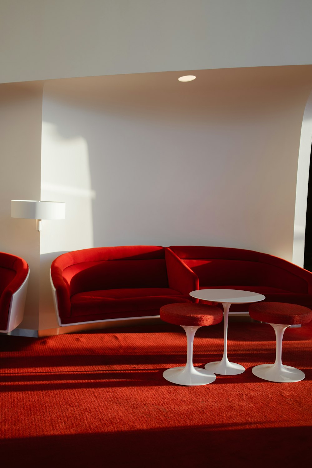 a red couch and two white tables in a room