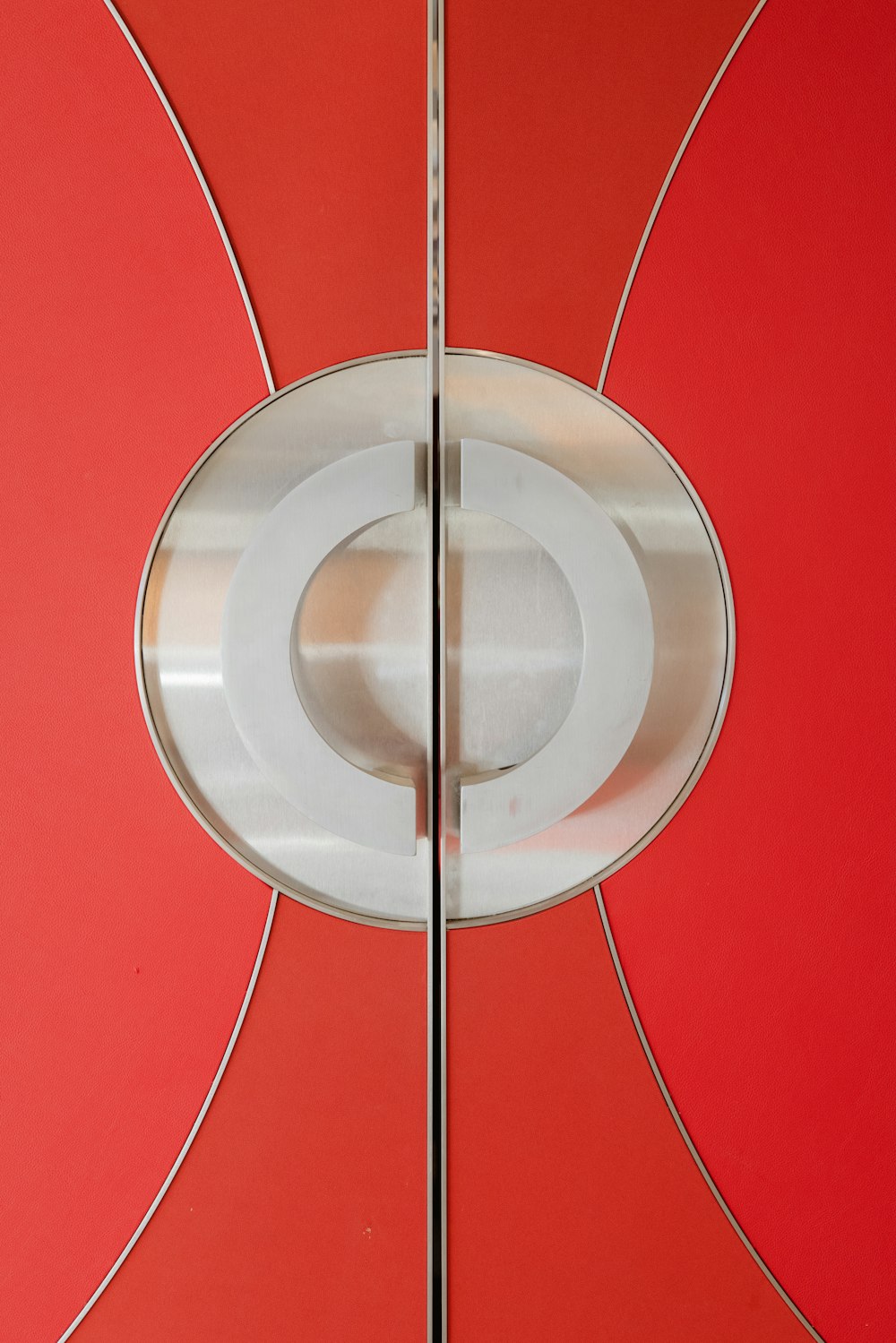 a close up of a metal door with a red background
