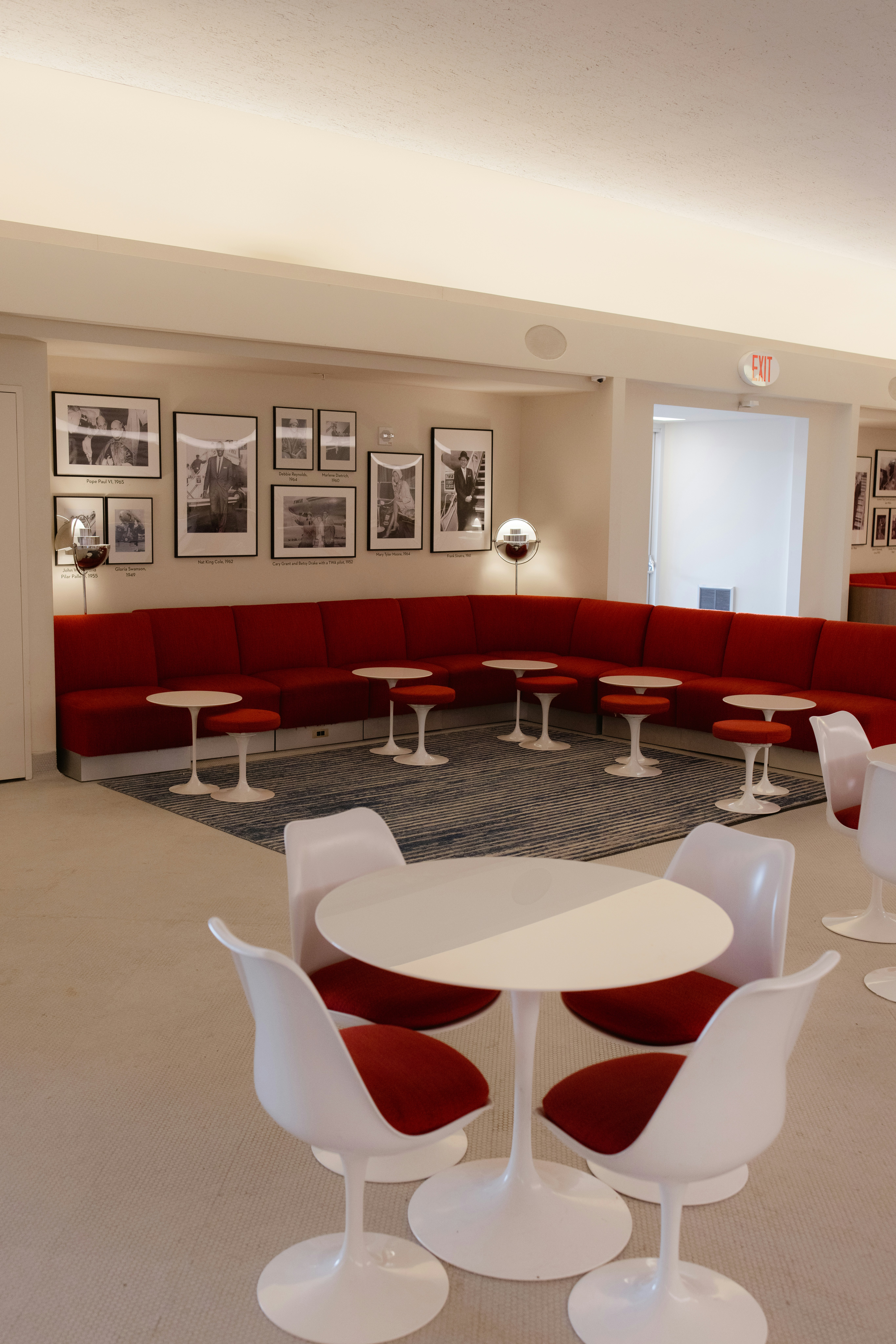 Una habitación con muebles rojos y blancos y cuadros en la pared
