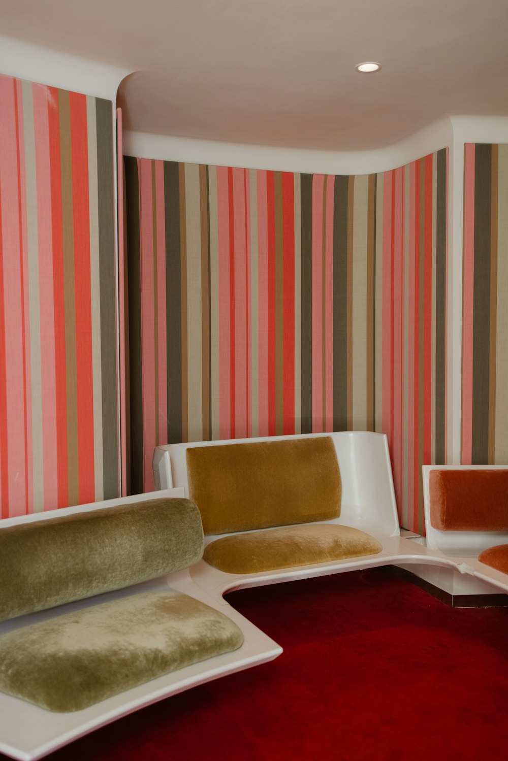 a living room with a red carpet and striped walls