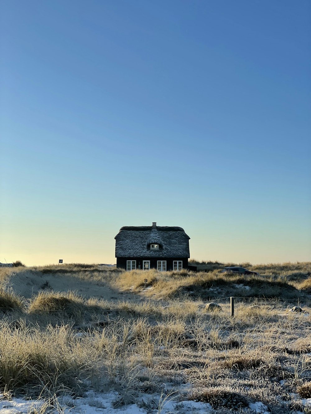 a house in the middle of a snowy field