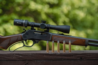 a rifle and some bullet shells on a wooden table
