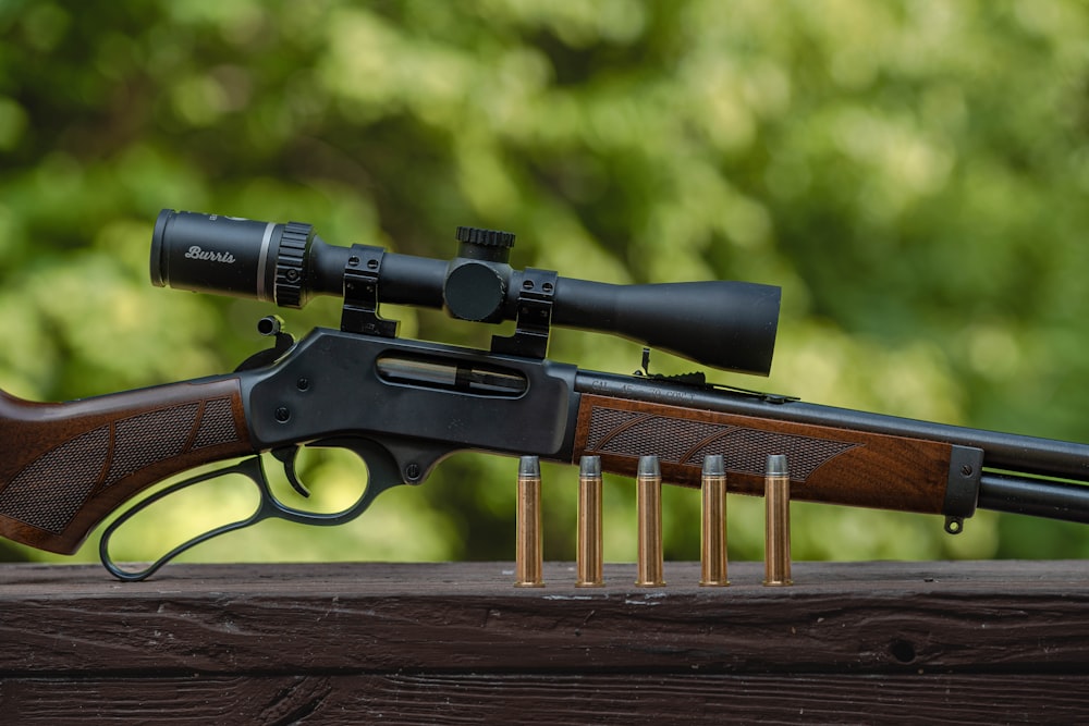 a rifle and some bullet shells on a wooden table