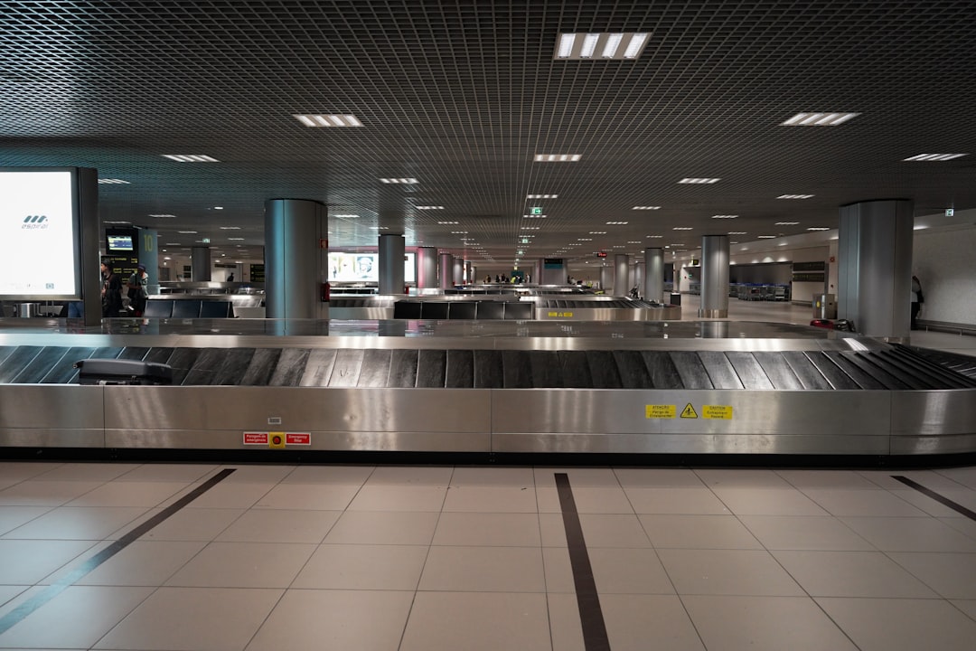 an empty baggage claim area at an airport, The arrivals baggage carousels in Lisbon Airport. Photograph by Mark Stuckey.