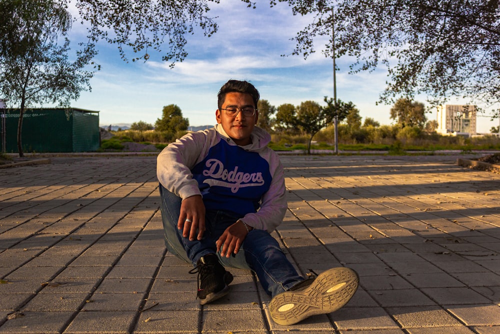 a man sitting on the ground with his foot on a shoe