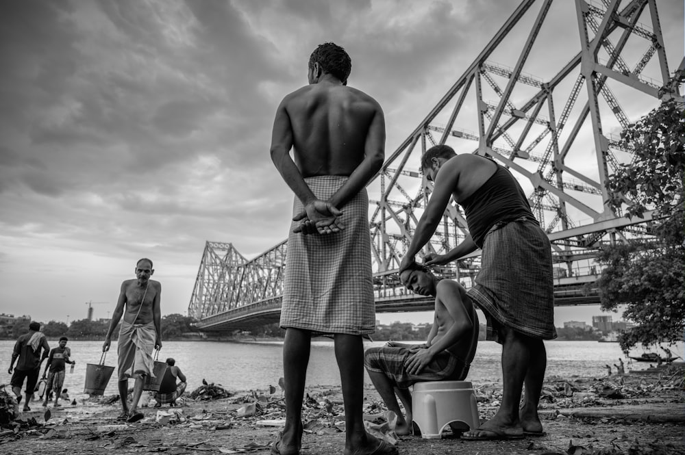 a group of men standing next to each other near a river