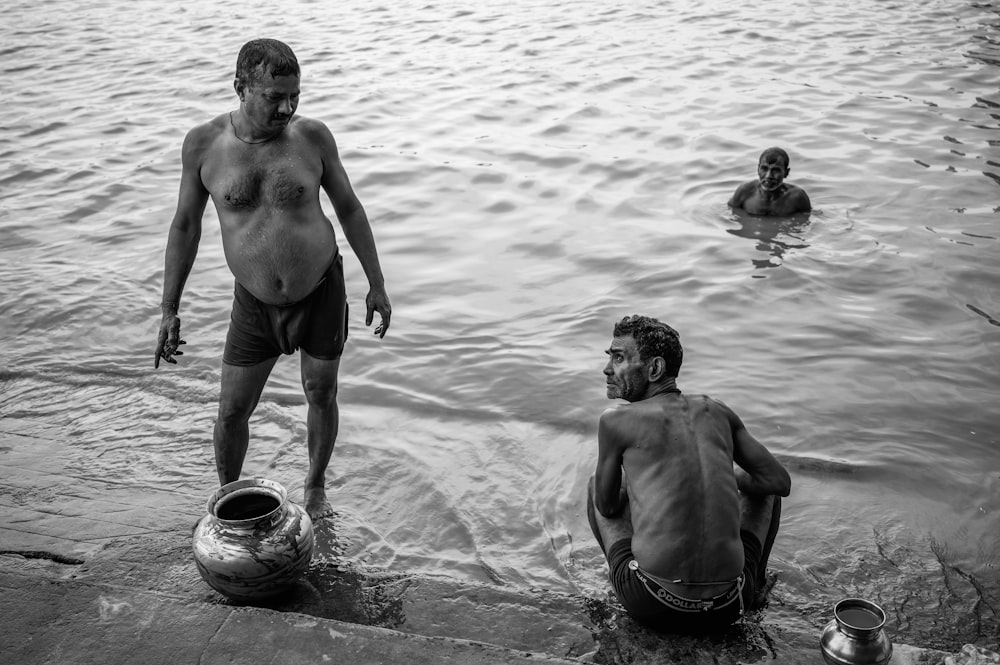 a man standing next to another man in the water