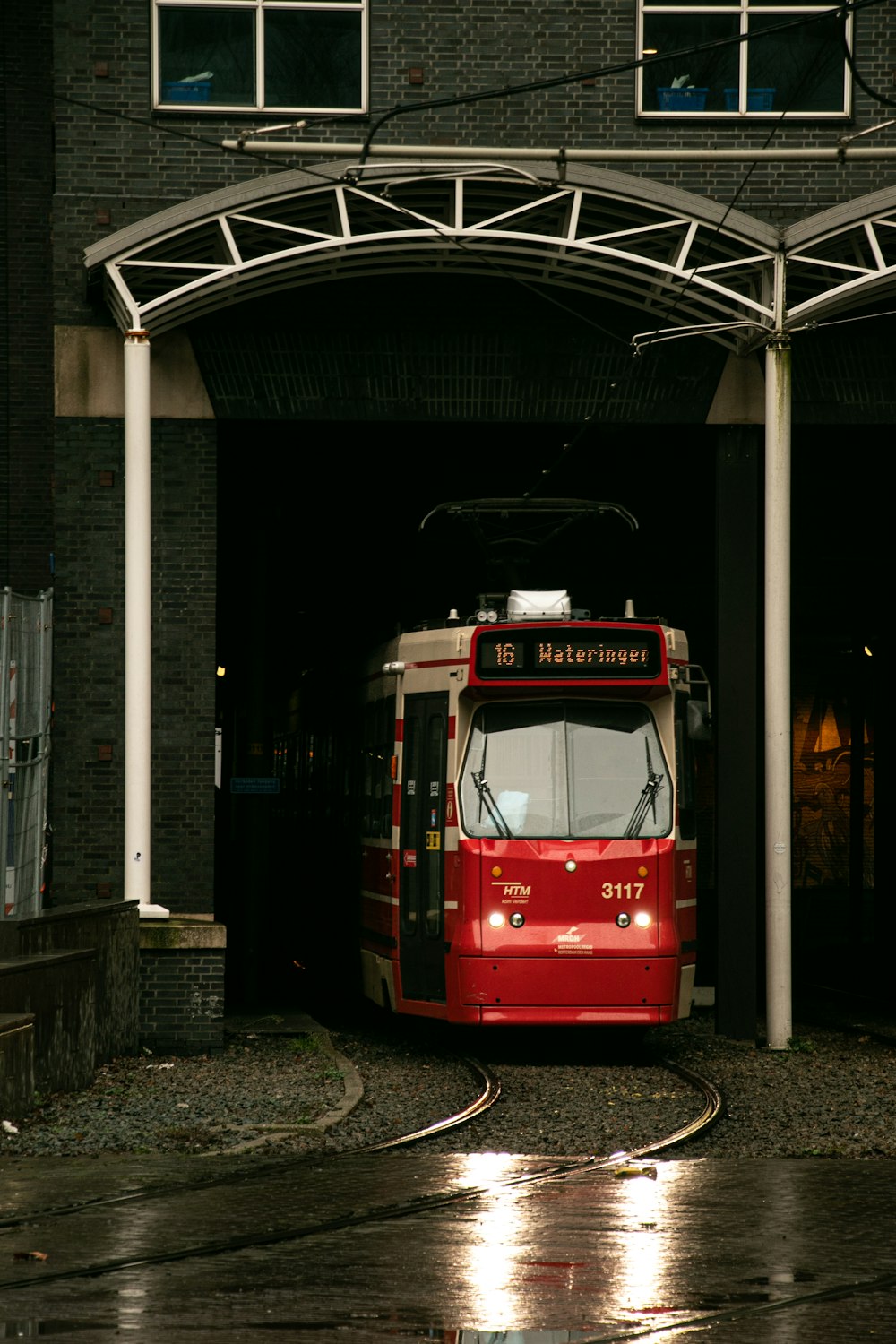 a red and white bus is coming out of a tunnel