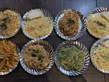 Overhead view of a rustic wooden table with four different pasta boxes arranged elegantly.