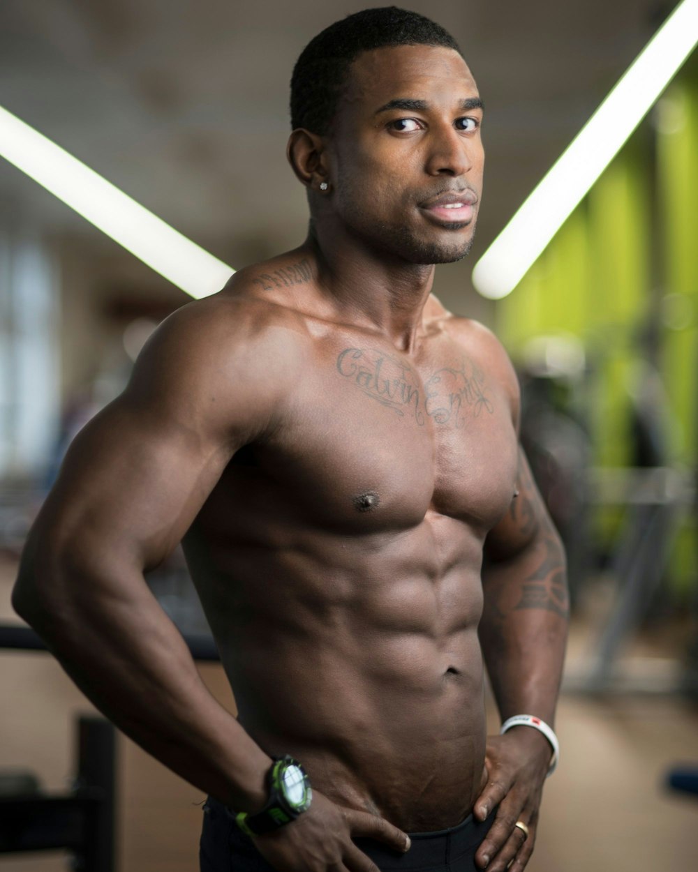 a shirtless man standing in a gym