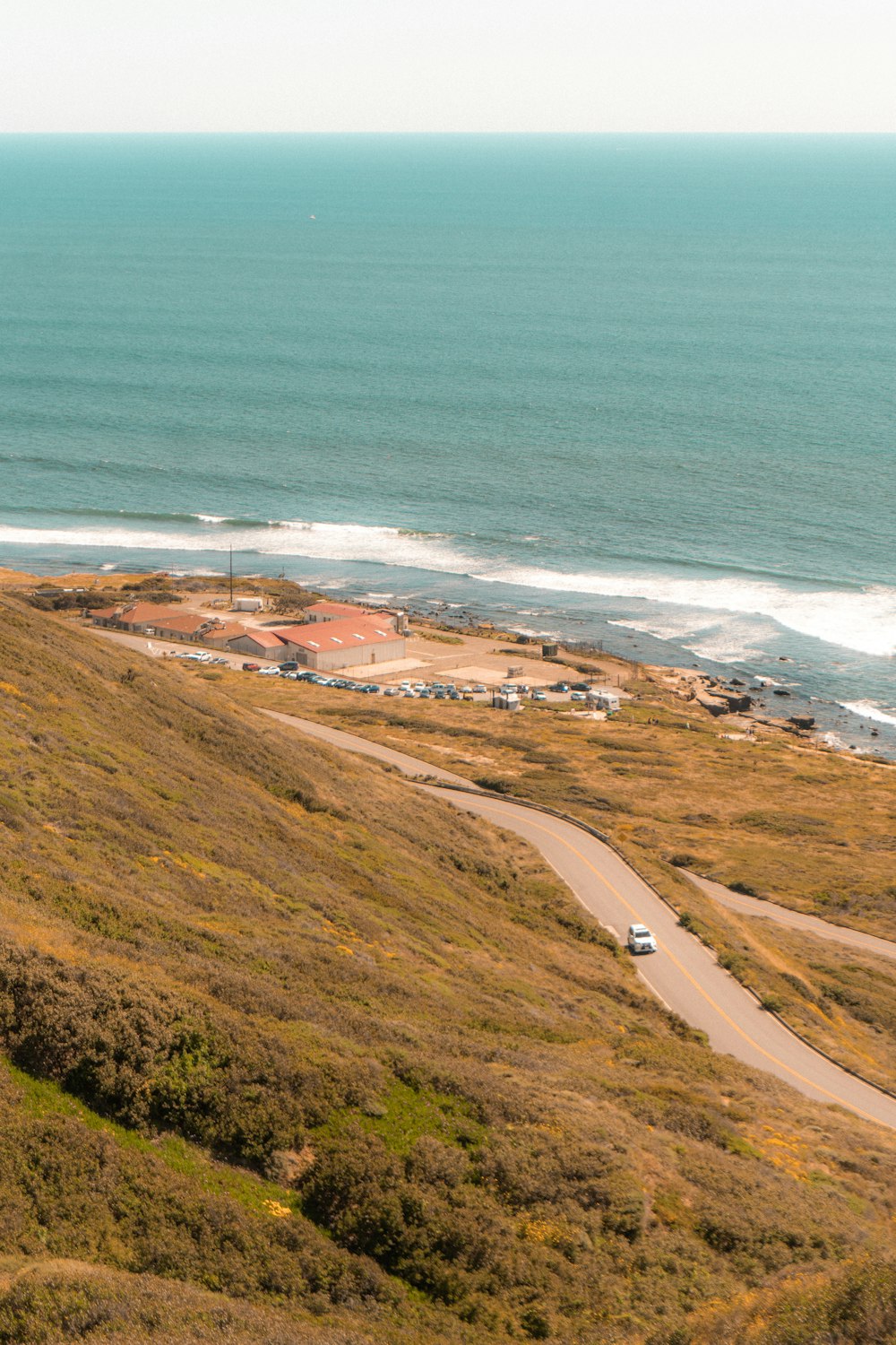 a car driving down a road next to the ocean