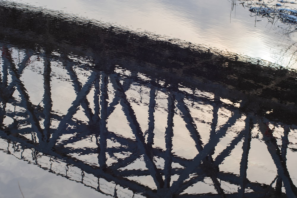 a reflection of a bridge in the water