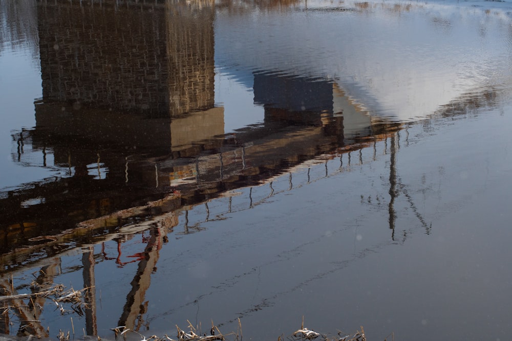 a reflection of a bridge in a body of water