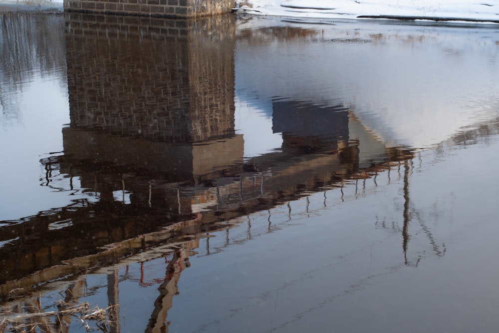 a reflection of a clock tower in the water