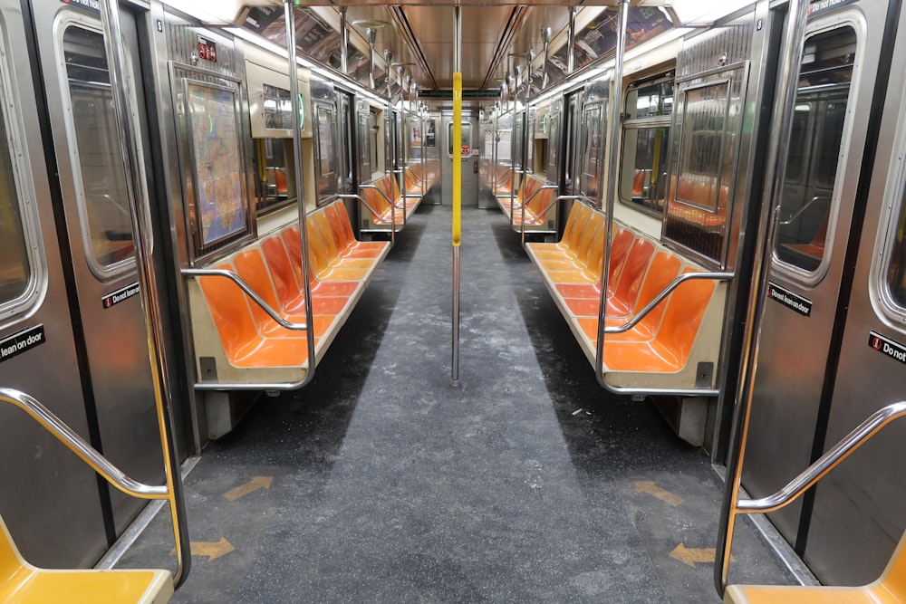 an empty subway car with orange seats