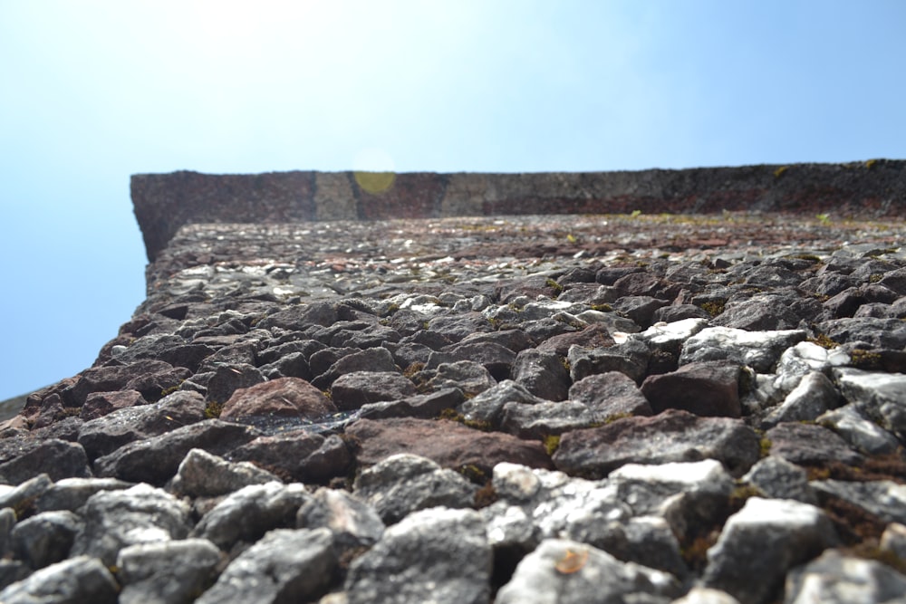 Un primer plano de un muro de piedra con un cielo azul en el fondo