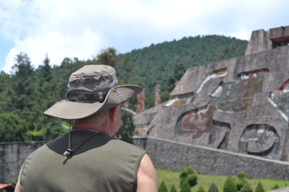 a man wearing a hat standing in front of a building