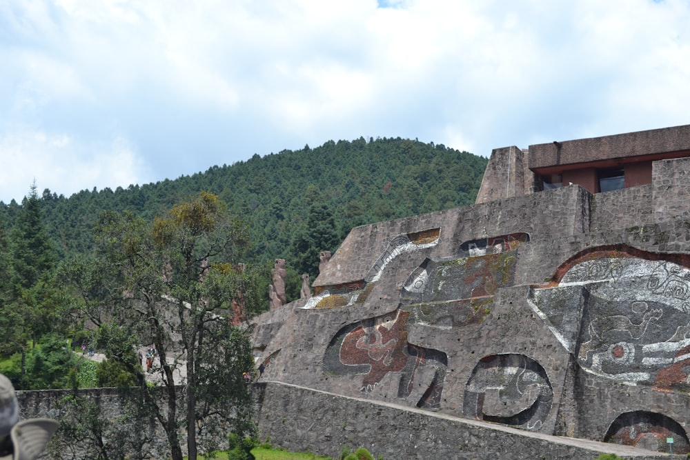 un gran edificio de piedra con un mural en el costado