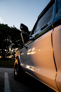 Close-up of a shiny chrome truck grill reflecting the vibrant colors of a sunset.