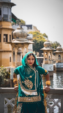 a woman in a green outfit standing on a bridge