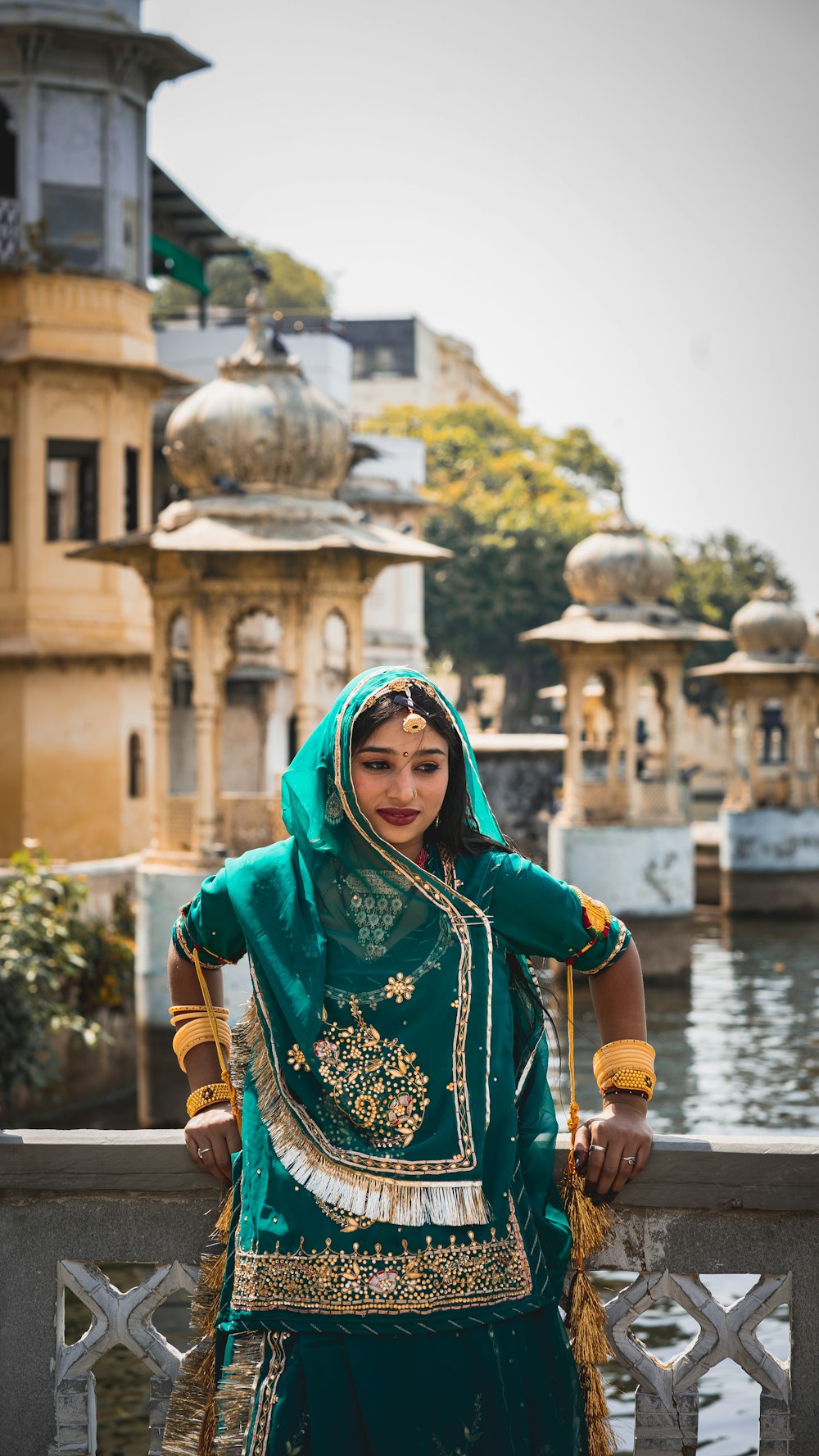 a woman in a green outfit standing on a bridge