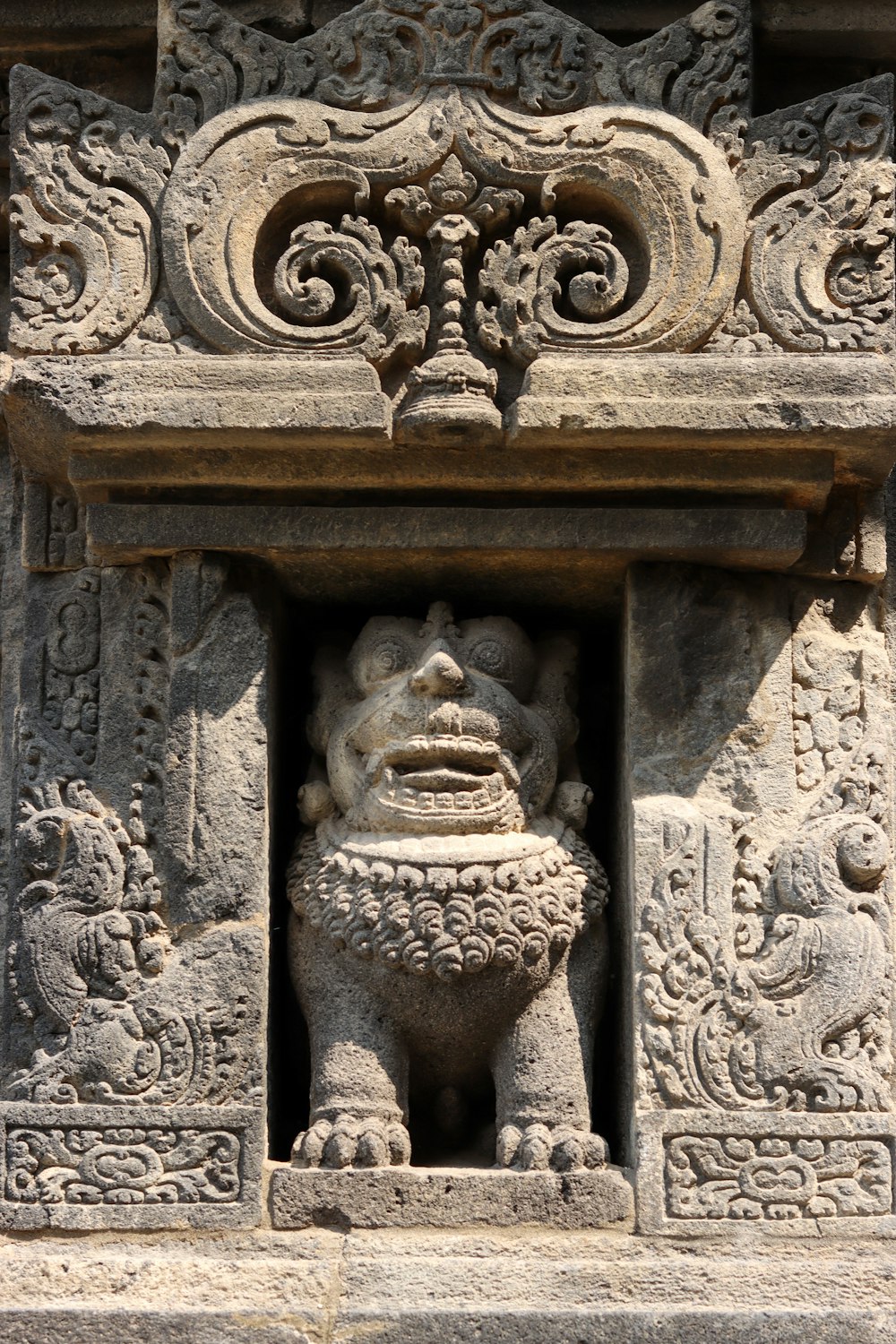 a stone carving of a lion with a face