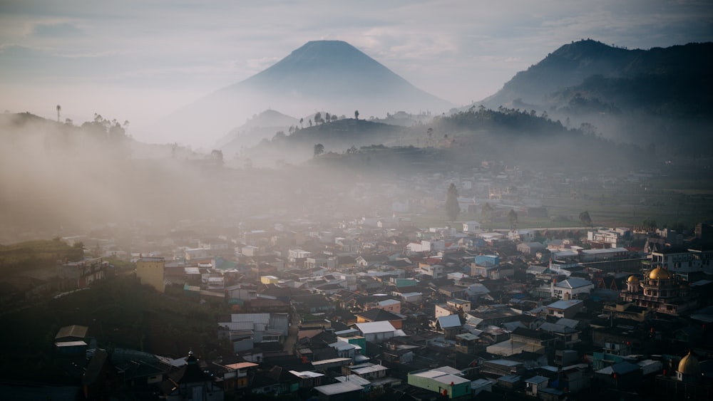 a foggy city with a mountain in the background