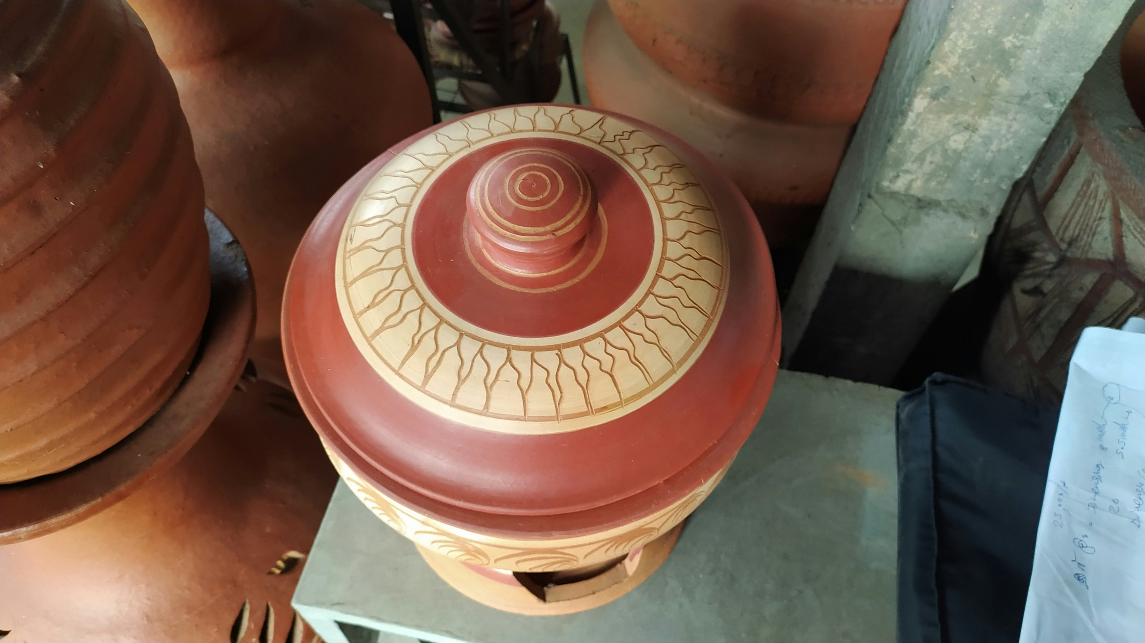 a red and white vase sitting on top of a table