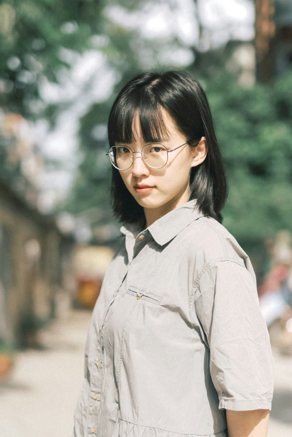 a woman with glasses standing on a street
