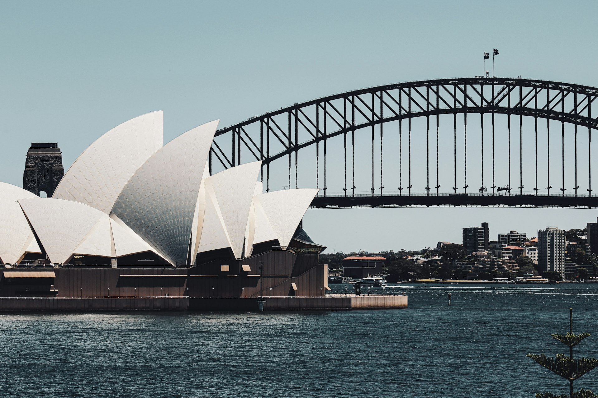 Sydney Opera House and Harbour Bridge viewed across the harbor in daylight