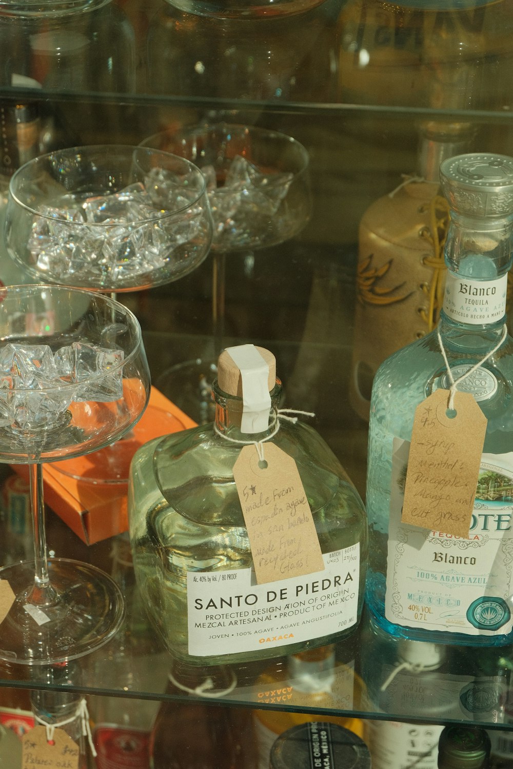 bottles of alcohol are on display in a glass case