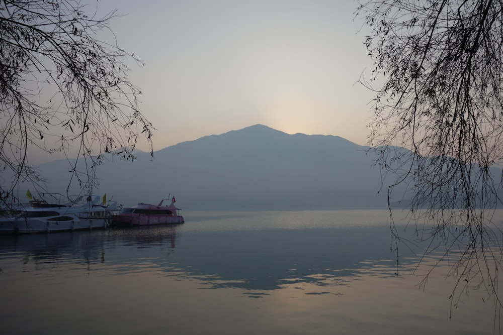 a body of water with boats in it and a mountain in the background