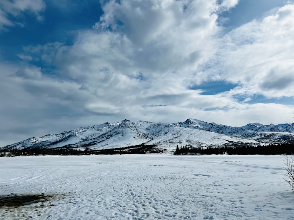 Un campo cubierto de nieve con montañas al fondo