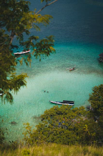 A serene lagoon with crystal-clear turquoise water and a small boat anchored nearby.