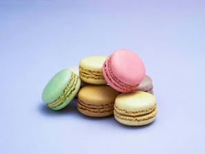 Top view of a tray filled with pastel-colored macarons in soft pink and brown tones